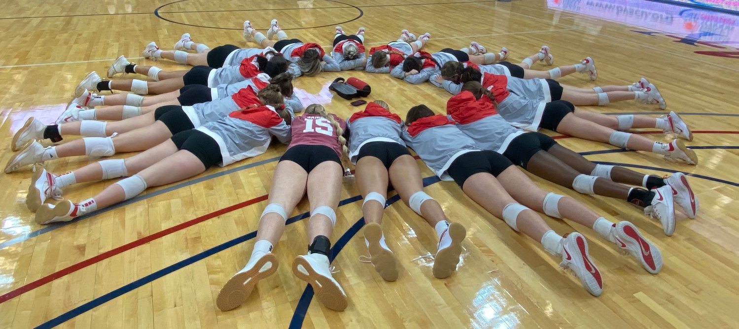 Katy High volleyball players take some quiet time together to meditate prior to their Class 6A regional semifinal against Clear Springs on Tuesday at the Merrell Center.